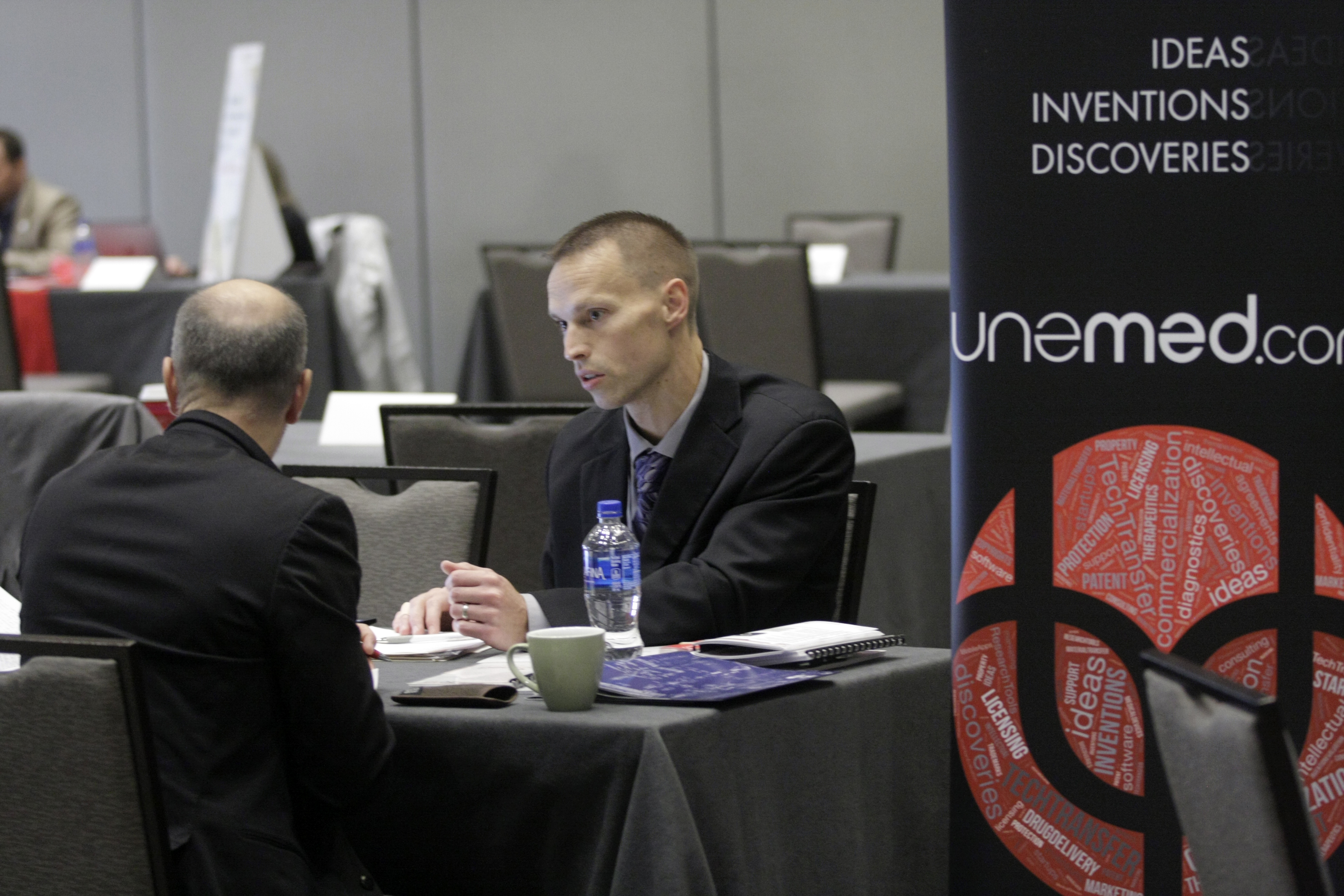 Matt Boehm, Licensing Manager at UNeMed, meets with an industry representative during aprtnering session at teh MidWest Drug Development Conference in October 2018. Boehm was also organized the event.